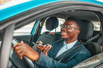 Close up of a handsome young businessman talking on mobile phone in his car. Man sitting in car and call. Young neglectful guy talking on his mobile phone while driving