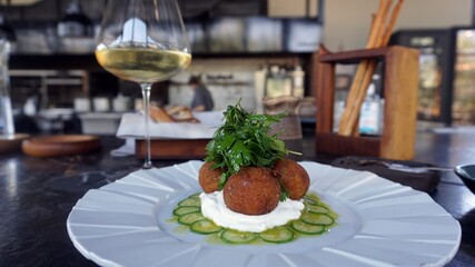 Falafel with yogurt sauce. Vegetarian cucumber, parsley, chickpea fritters Falafel served with yogurt sauce on plate. Selective focus. Healthy vegetarian food with white wine