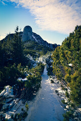 Beautiful winter landscape in the mountains	with clouds and snow covered road.
