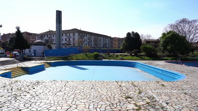 Europe, Italy , Milan April 2021 - empty swimming pool without water and people swimming during Covid-19 Coronavirus lockdown quarantine home - preparation work for the sport reopening - Argelati