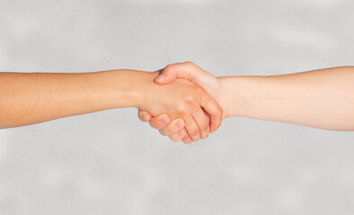 Two hands concept. Hands holding each other on the outstretched arm. Close up isolated arm, hands. Gestures of help, rescue or handshake between people, friends, partners or colleagues.