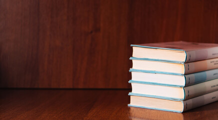 Banner with wide bookshelf and a stack of hardcovered books with bookmarks. Literature background with copy space for advertisement text