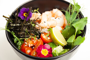 Poke salad with shrimp in a bowl. Ingredients Shrimp, blanched spinach, cherry tomatoes, rice, cucumber, soy-ginger sauce, Spicy sauce, nori, sesame, lime, cilantro. Asian seafood salad concept.