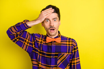 Obraz premium Photo of crazy loser man open mouth palm brow wear bow tie plaid shirt isolated yellow color background