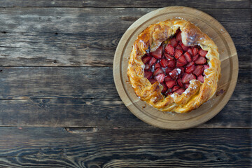 tart with strawberries on a wooden table. Copy space, top view.