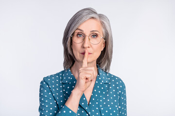 Photo of serious old woman hold finger mouth lips silence tell secret isolated on grey color...