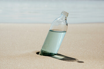 reusable water bottle on the sand of a beach