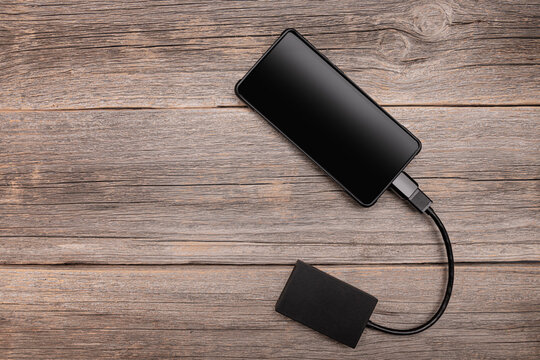 Memory card or external hard drive is connected to the smartphone via an OTG cable.