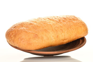 One fresh aromatic ciabatta on a clay plate, close-up, isolated on white.
