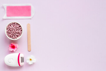Cosmetics set for epilation with epilator and wax strips and flowers. Top view