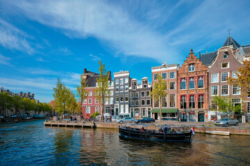 Fototapeta na wymiar Amsterdam view - canal with boad, bridge and old houses