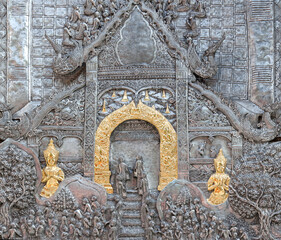 Detail of aluminium and silver bas-relief with stories of Buddhism, dharma puzzles, and the history of the Wat Sri Suphan, or Silver temple in Chiang Mai, Thailand