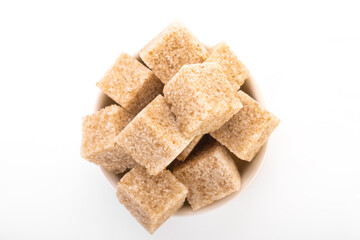 brown sugar cubes. brown sugar in white bowl on white background. sugar cubes, cane sugar