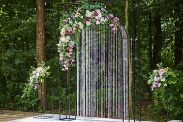 Fototapeta na wymiar Beautiful wedding arch for ceremony in rustic style located in forest