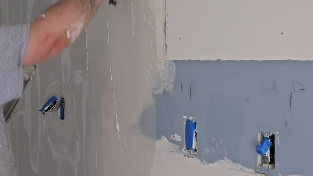Worker puttied wall using a paint spatula hand worker repairs gypsum plasterboard