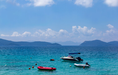 Relaxing view off boats on the blue sea with mountains in the background from the beach shore in Slano, Croatia during summer vacations.