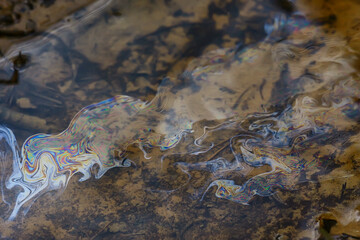 oil spills on puddle background, abstract gasoline nature pollution concept