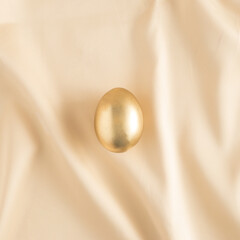 Luxury Easter composition with gold eggs on a satin background. Minimal luxury Easter concept. Flat lay.