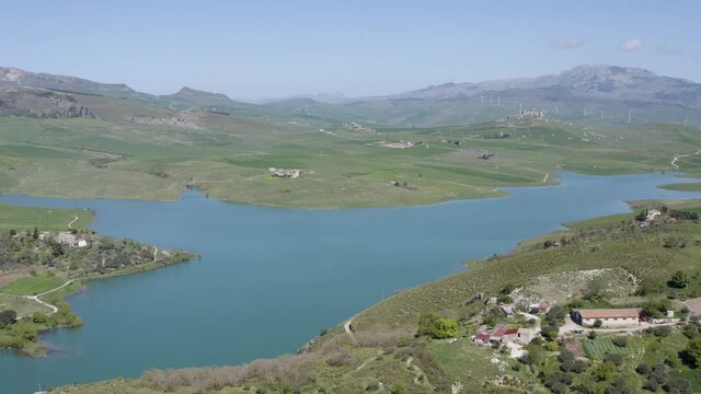 Lake Prizzi in the heart of the Sicani mountains in Sicily. Lush vegetation with wheat crops. Rurality in Sicily. Green in Sicily in spring. Relax by the lake. Migratory birds.