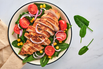Chicken fillet with salad spinach, cherry tomatoes, cornflower and onion. Healthy food. Keto diet, diet lunch concept. Top view on white background.