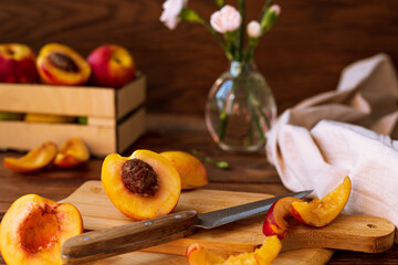 sliced nectarines on a chopping board on a wooden table. halves and slices of sweet peach in the kitchen