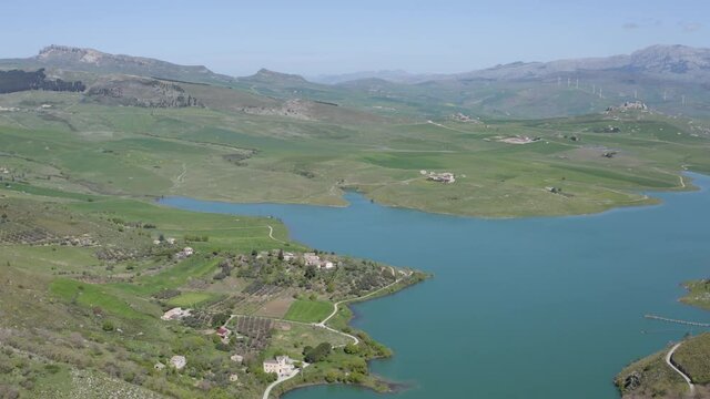 Lake Prizzi in the heart of the Sicani mountains in Sicily. Lush vegetation with wheat crops. Rurality in Sicily. Green in Sicily in spring. Relax by the lake. Migratory birds.