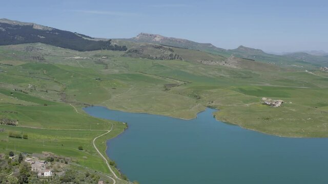 Lake Prizzi in the heart of the Sicani mountains in Sicily. Lush vegetation with wheat crops. Rurality in Sicily. Green in Sicily in spring. Relax by the lake. Migratory birds.