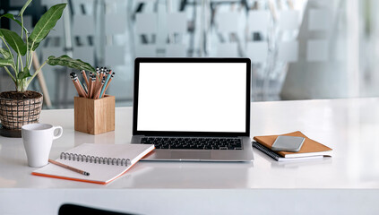 Fototapeta premium Mockup blank screen laptop and supplies on white wooden table.