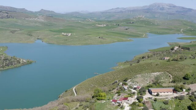 Lake Prizzi in the heart of the Sicani mountains in Sicily. Lush vegetation with wheat crops. Rurality in Sicily. Green in Sicily in spring. Relax by the lake. Migratory birds.