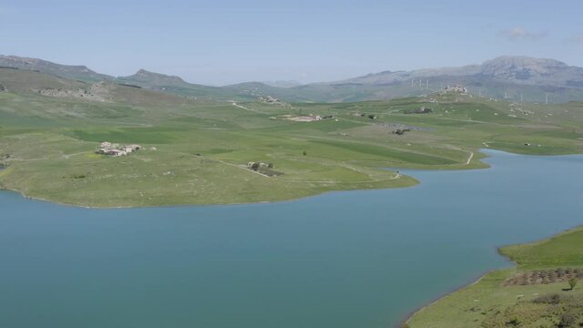 Lake Prizzi in the heart of the Sicani mountains in Sicily. Lush vegetation with wheat crops. Rurality in Sicily. Green in Sicily in spring. Relax by the lake. Migratory birds.