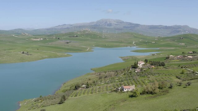 Lake Prizzi in the heart of the Sicani mountains in Sicily. Lush vegetation with wheat crops. Rurality in Sicily. Green in Sicily in spring. Relax by the lake. Migratory birds.
