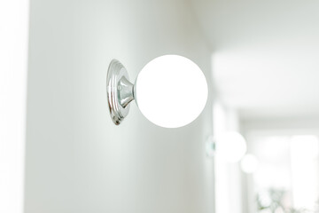 Close up photo of a minimalistic white wall lamp.