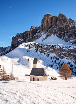 Wolkenstein in Gr&ouml;den in winter with chapel and view to the pizes de cir, Dolomite, Italy