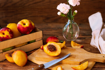 sliced nectarines on a chopping board on a wooden table. halves and slices of sweet peach in the kitchen