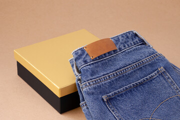 close-up leather empty tag or label on the back pocket of blue jeans on a vase of spool yarn with...