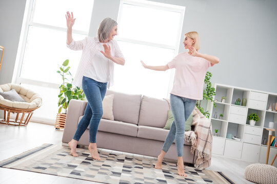 Full length photo of attractive active old woman and young lady dance wear casual clothes indoors inside house home