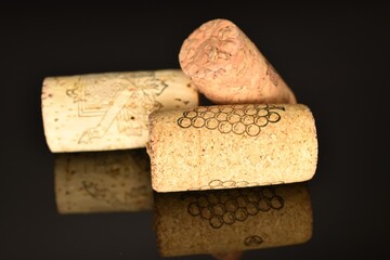 Three wine corks, close-up, on a black background.