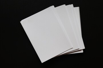 A pile of white paper on black background