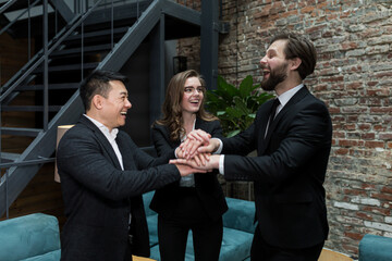 The team of employees hold hands together, rejoice in the work done, and overcome difficulties, the team successfully works together