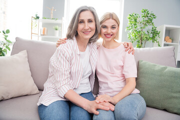 Photo of happy positive cheerful women old lady young girl sit sofa smile hug family indoors inside house home