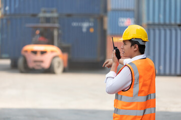 back view shot factory worker or engineer using walkie talkie for preparing a job in containers warehouse storage