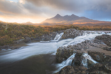 Dramatic, atmospheric landscape of golden sunset or sunrise light over Sligachan River and Black Cuillin mountains on the Isle of Skye, Scottish Highlands, Scotland.