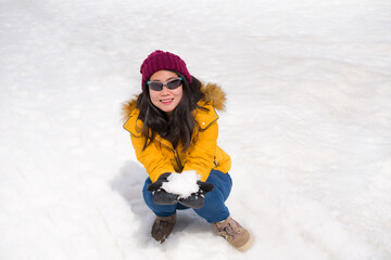 winter holidays - young happy and attractive Asian Korean woman enjoying playful on snow at beautiful Swiss Alps landscape during Christmas vacation trip