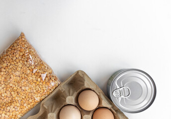 Flatlay food donation. Products  on white isolated background, top view,  chicken eggs, canned food. Helping