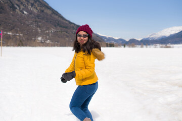 Fototapeta na wymiar winter holidays - young happy and attractive Asian Chinese woman enjoying playful on snow at beautiful Swiss Alps landscape during Christmas vacation trip