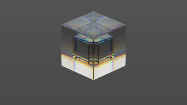 A cube of transparent material moves vertically against a gray background, making it possible to see another cube that rotates inside. Refraction of light. Seamless loop.