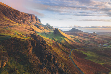 Golden light at sunset or sunrise over colourful landscape view of the rugged, otherworldly terrain of the Quiraing on the Isle of Skye, Scotland.