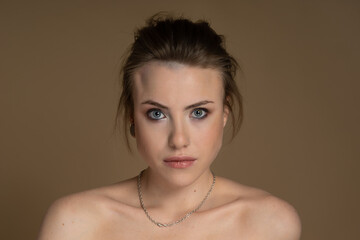Sexy girl with heterochromia, looks expressively at camera, nose piercing and plug in one ear, and...
