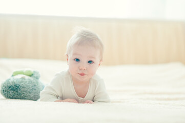 handsome cheerful boy crawling on the bed.