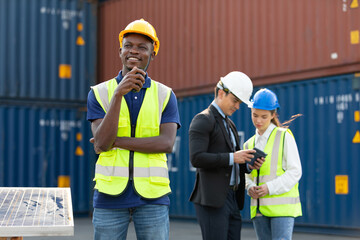 African factory worker or engineer using walkie talkie for preparing a job in containers warehouse storage